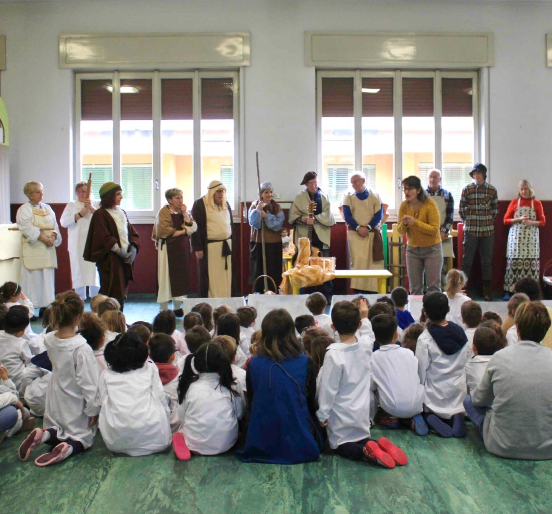 Momento comunitario con bambini e adulti durante un'attività legata alle radici cattoliche della scuola